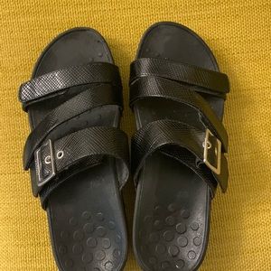 Vionic black wedge sandals with adjustable velcro straps and silver buckle.